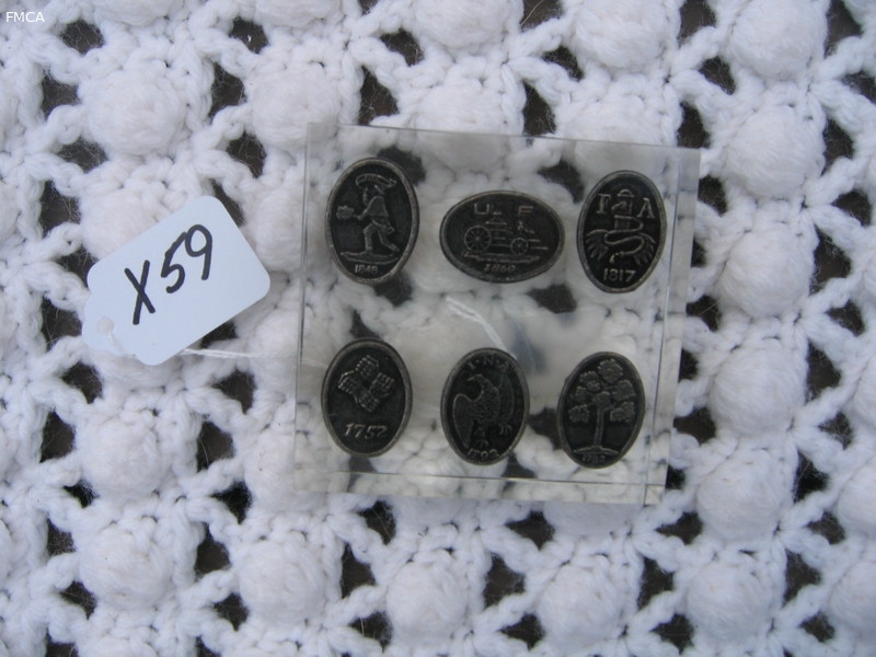 Six miniature fire marks encased in a clear holder