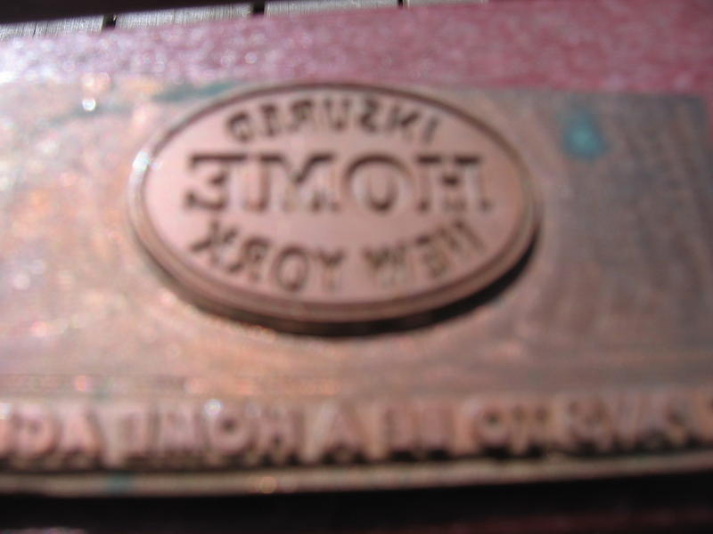 Brass Stamp. Raised Oval that says Insured Home N