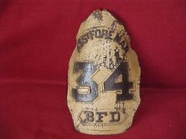 Foreman Shield. Beige with dark brown lettering.