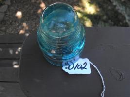 Insulator. Turquoise glass. Etched on front is "